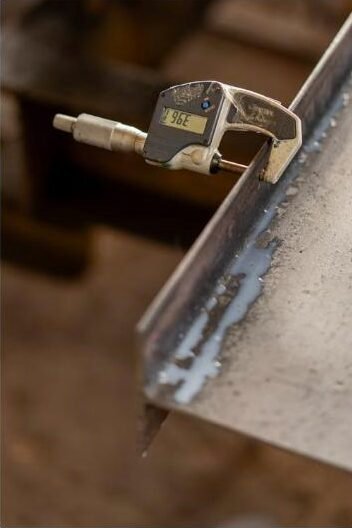 Digital micrometer measuring the thickness of a material edge